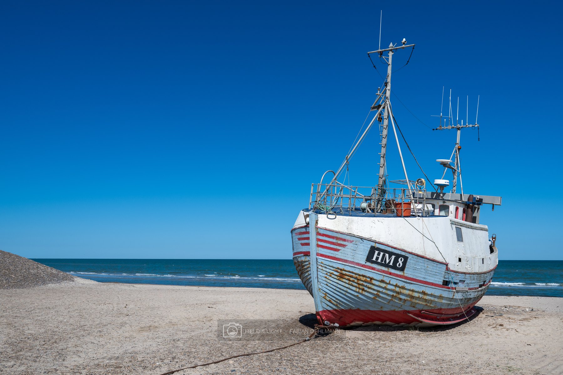 Weathered fishing boat HM 8 resting on the beach at Thorup Strand